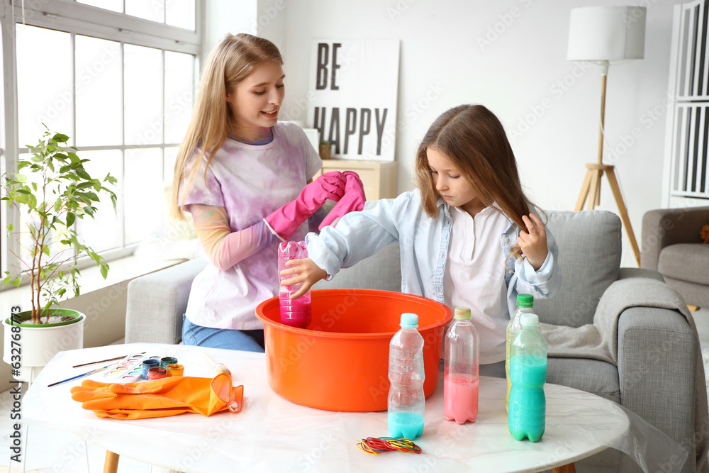 Little girl with her sister making tie-dye t-shirt at home