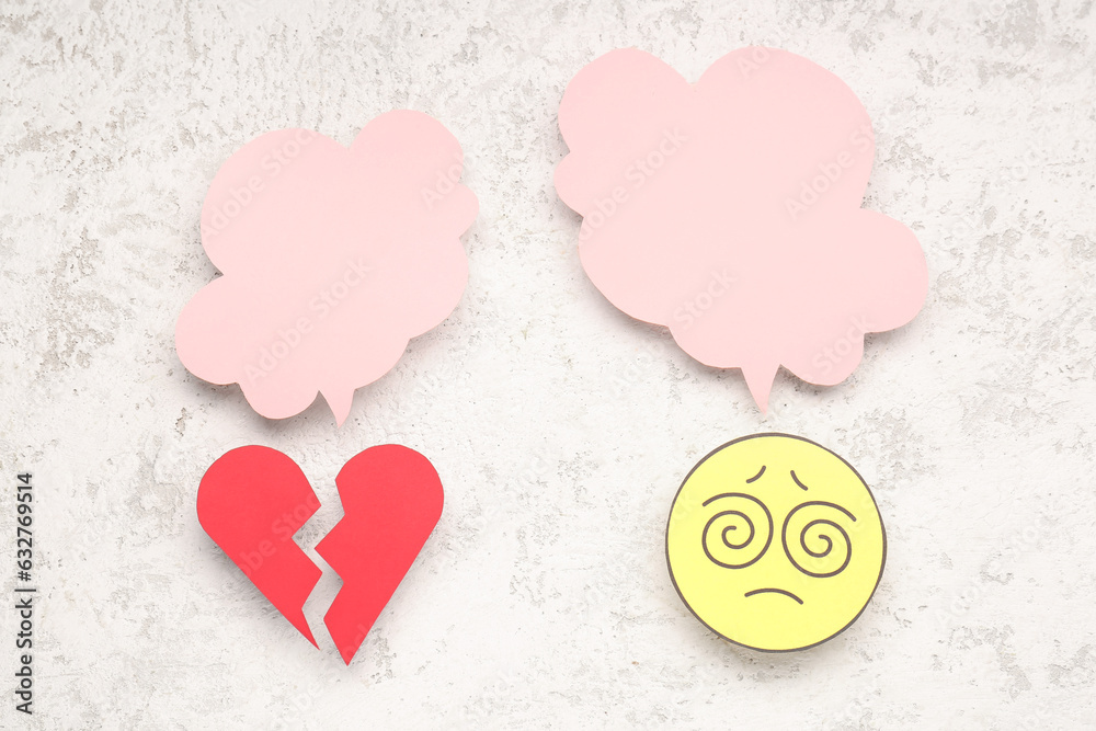 Confused paper face and broken heart with blank speech bubbles on light background