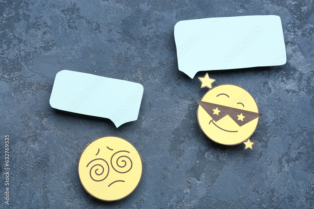 Paper faces with with blank speech bubbles on dark blue background