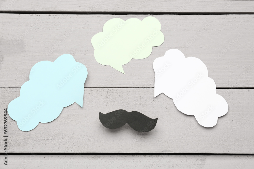 Paper mustache with blank speech bubbles on grey wooden background