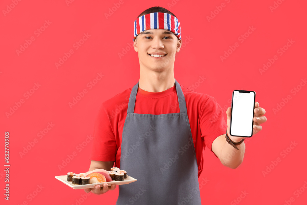 Young man with tasty sushi and mobile phone on red background