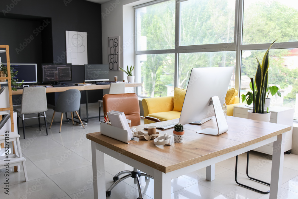 Programmers workplace with computer and laptop in office