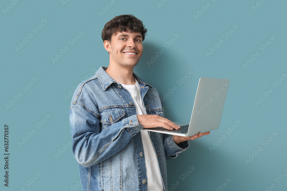 Male programmer working with laptop on blue background