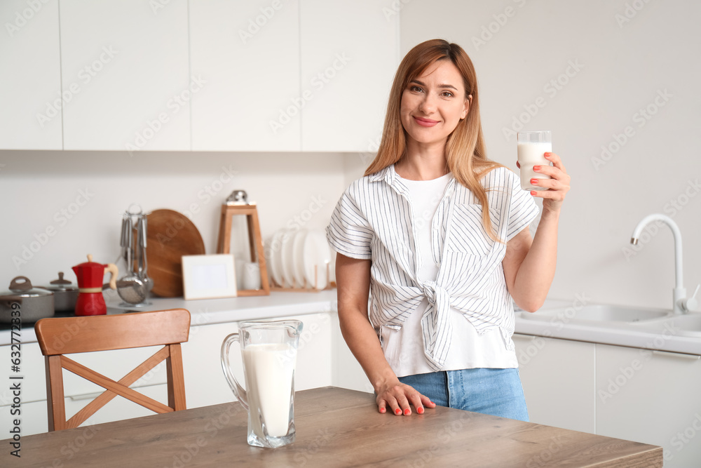 Young woman with glass of milk in kitchen