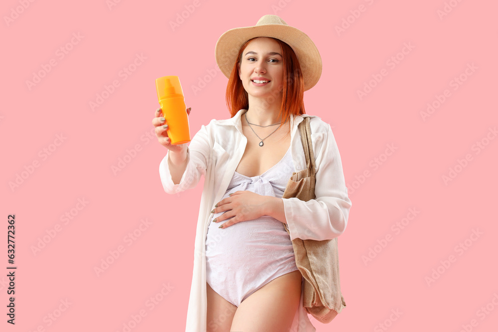 Young pregnant woman with sunscreen cream on pink background