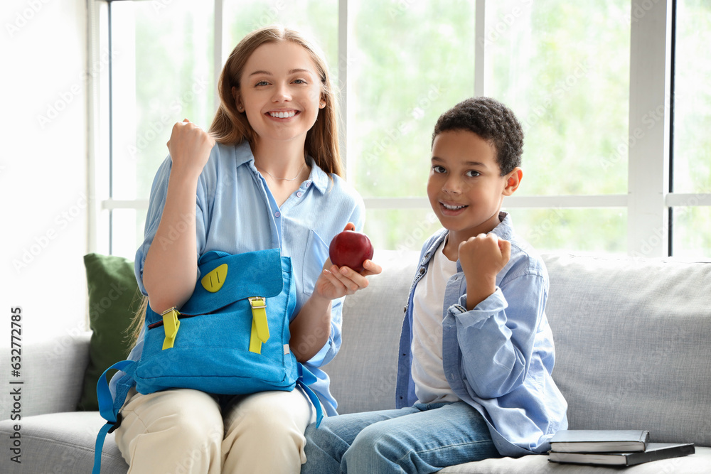 Happy African-American schoolboy with his mother at home