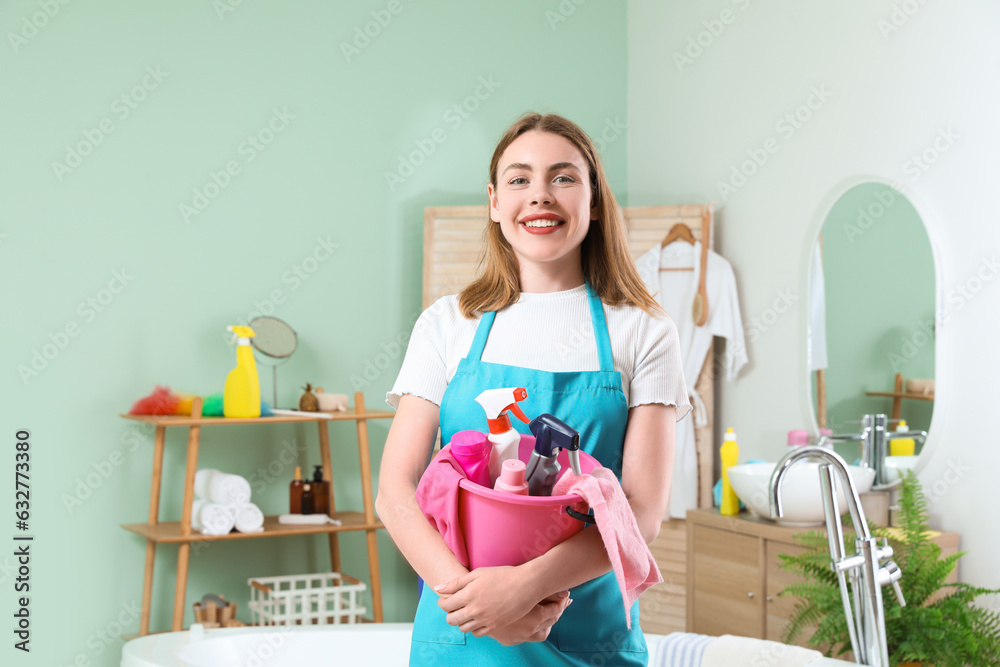 Young woman with cleaning supplies in bathroom