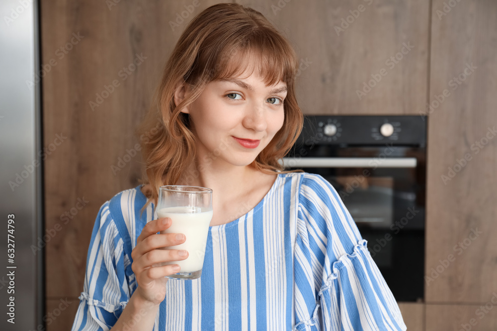 Young woman with glass of milk in kitchen, closeup