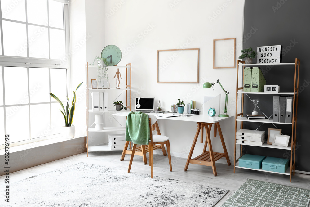 Interior of light office with workplace and shelving units