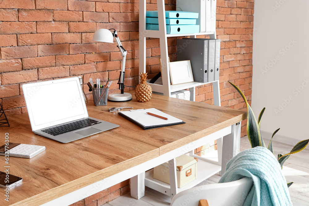 Modern workplace with laptop and stationery in office