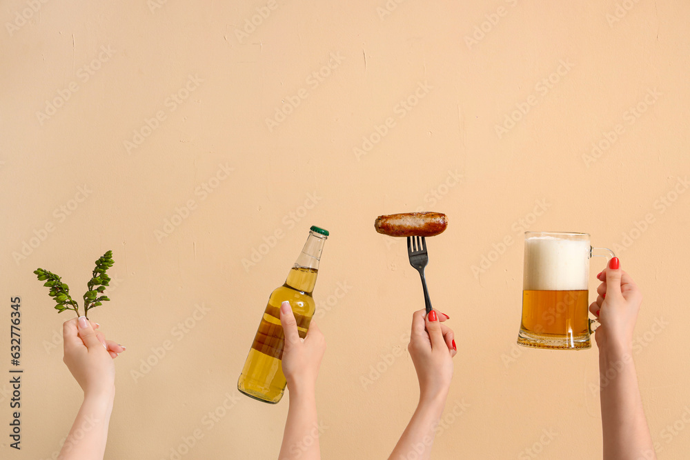 Women with beer, hop and sausage on beige background