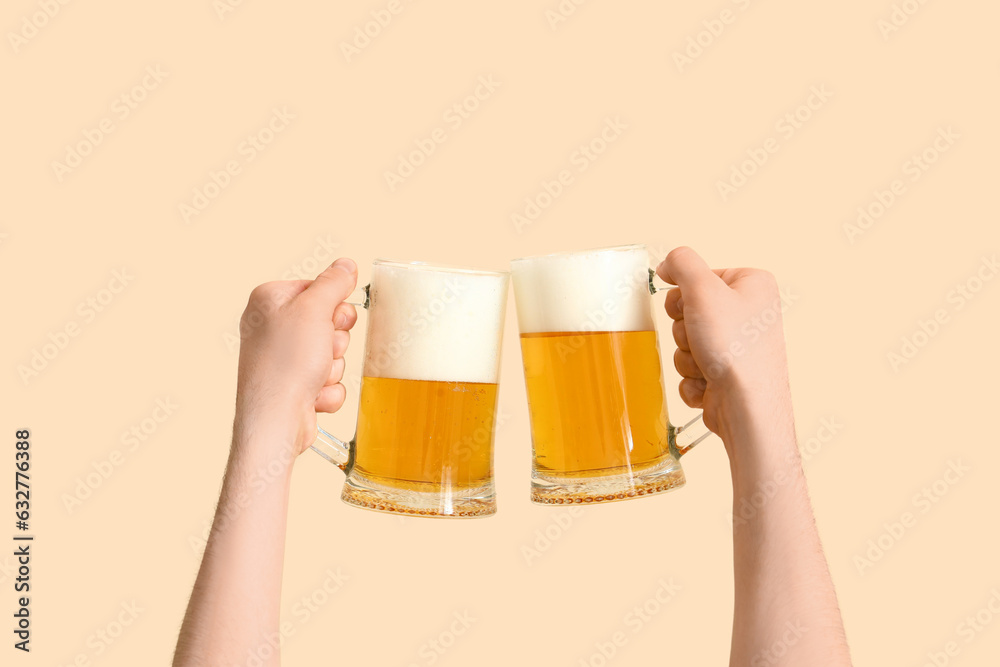 Man with glasses of beer on beige background