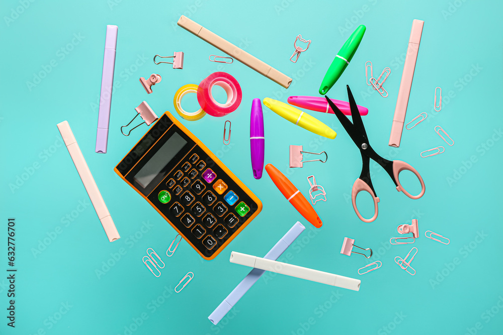 Flying stationery and calculator on color background