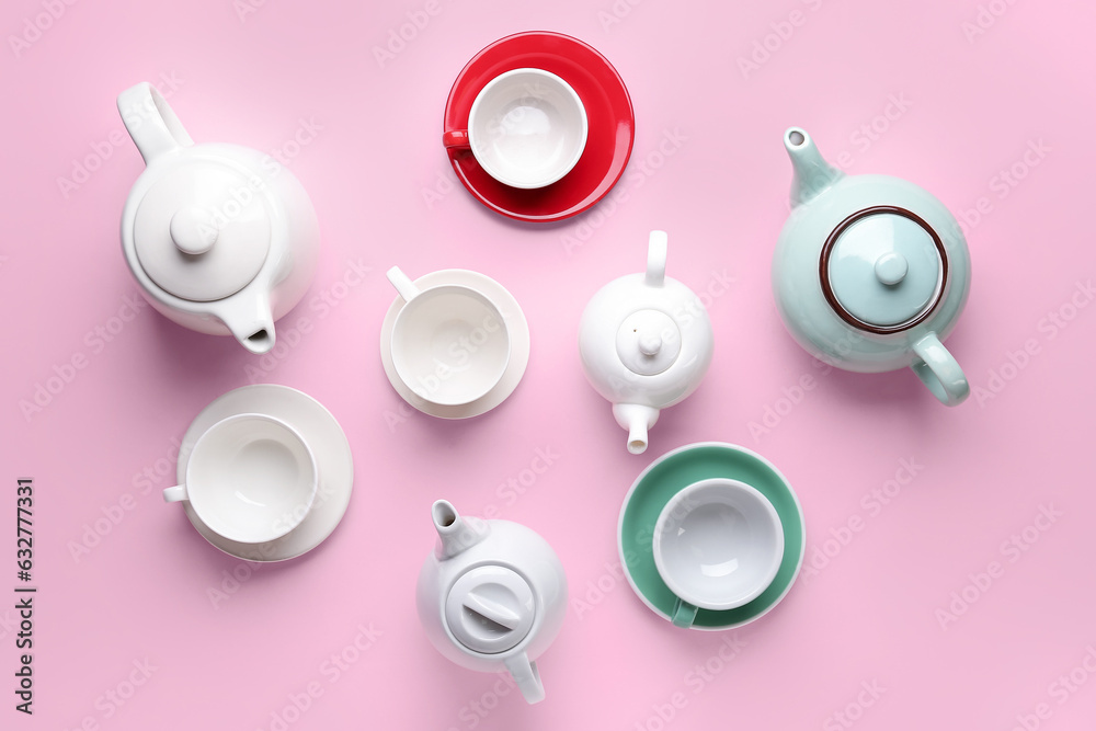 Composition with different cups and teapots on pink background