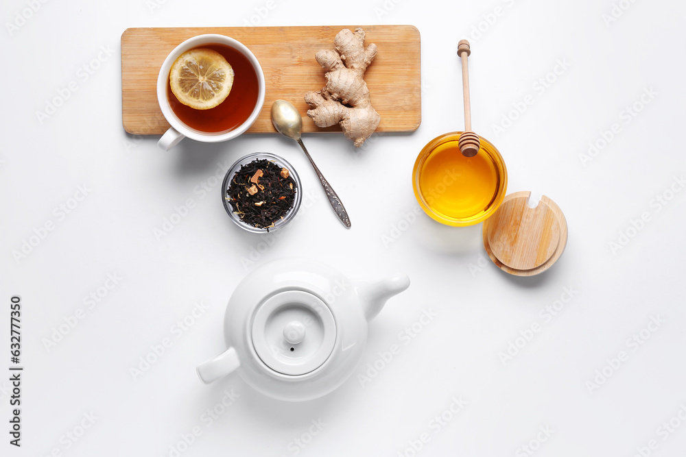 Composition with teapot, cup of tea and ingredients on light background