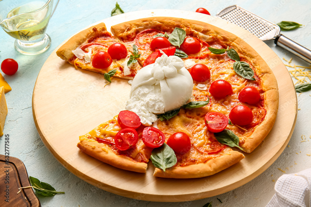 Wooden board of tasty pizza with Burrata cheese on blue background