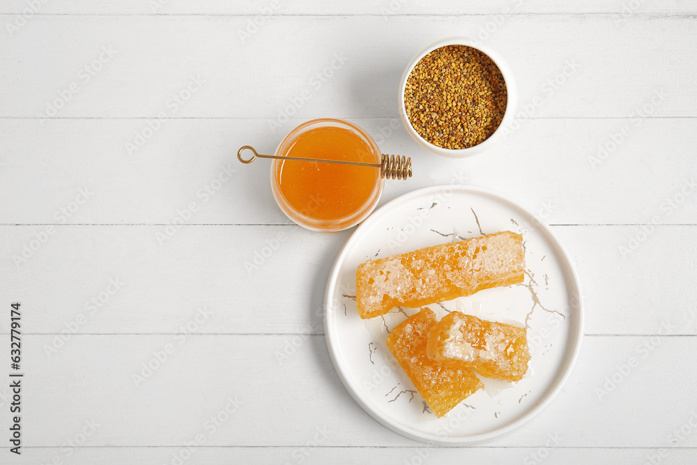 Jar of honey, sweet combs and bee pollen on light wooden background