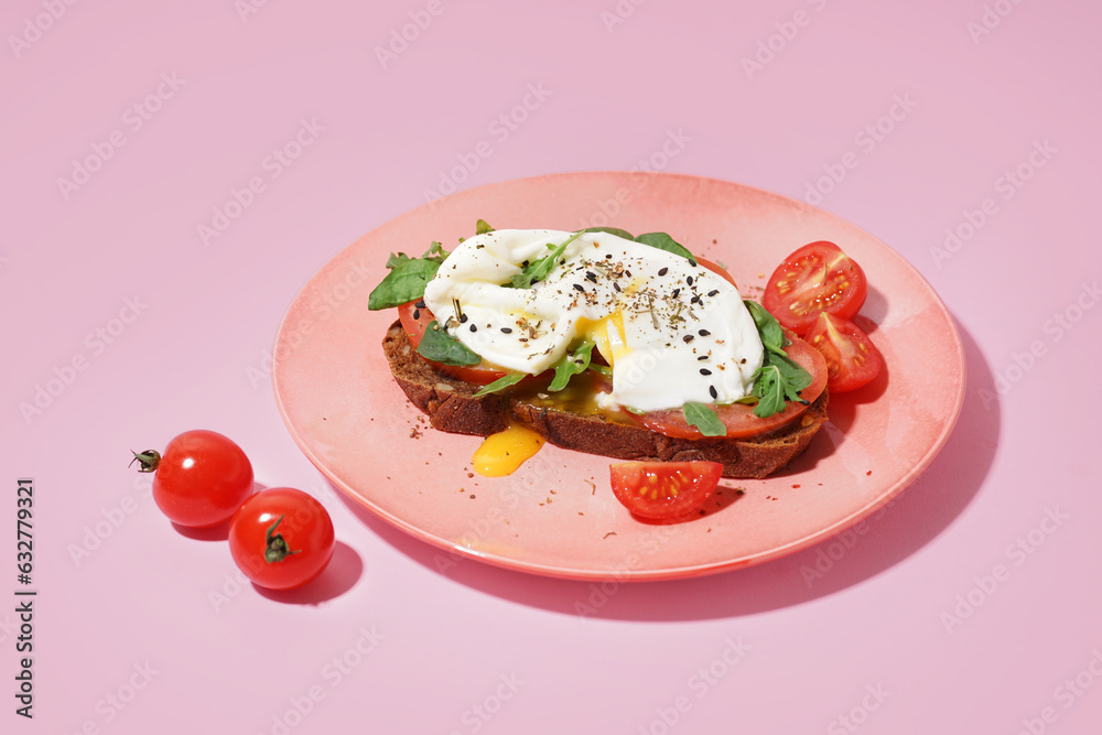 Plate of tasty sandwich with egg on pink background