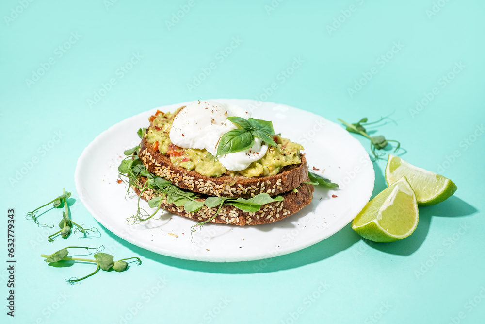 Plate of tasty sandwich with egg on turquoise background