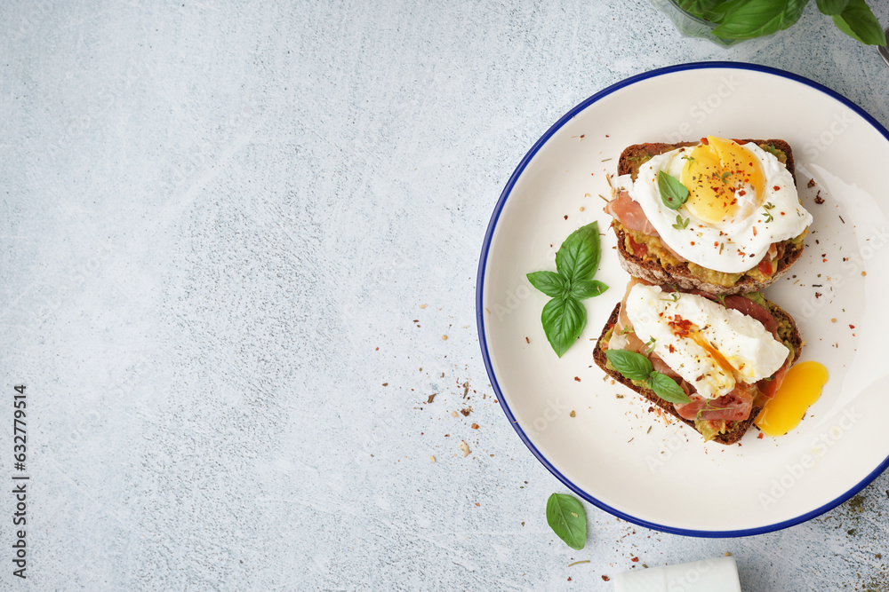 Plate of tasty sandwiches with egg on grey background