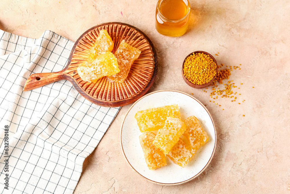 Wooden board and plate with sweet honeycombs on beige background