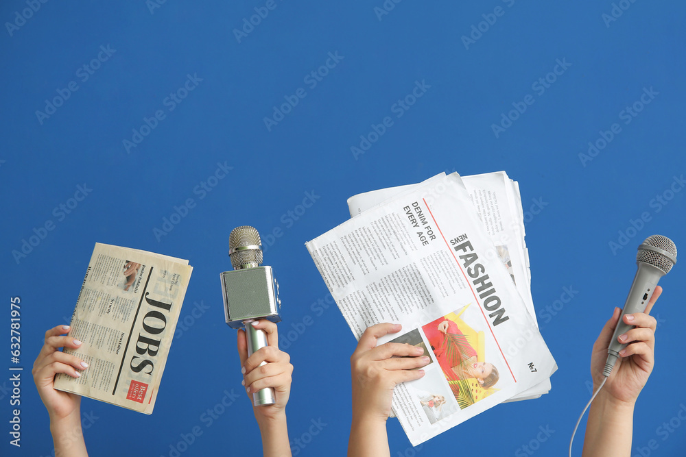 Female hands with microphones and newspapers on blue background