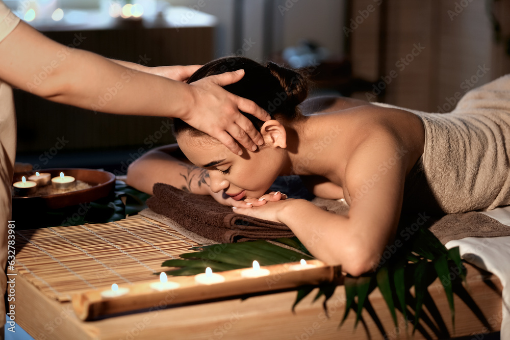 Pretty young woman having massage in spa salon