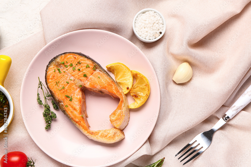 Plate of tasty salmon steak lemon on white background