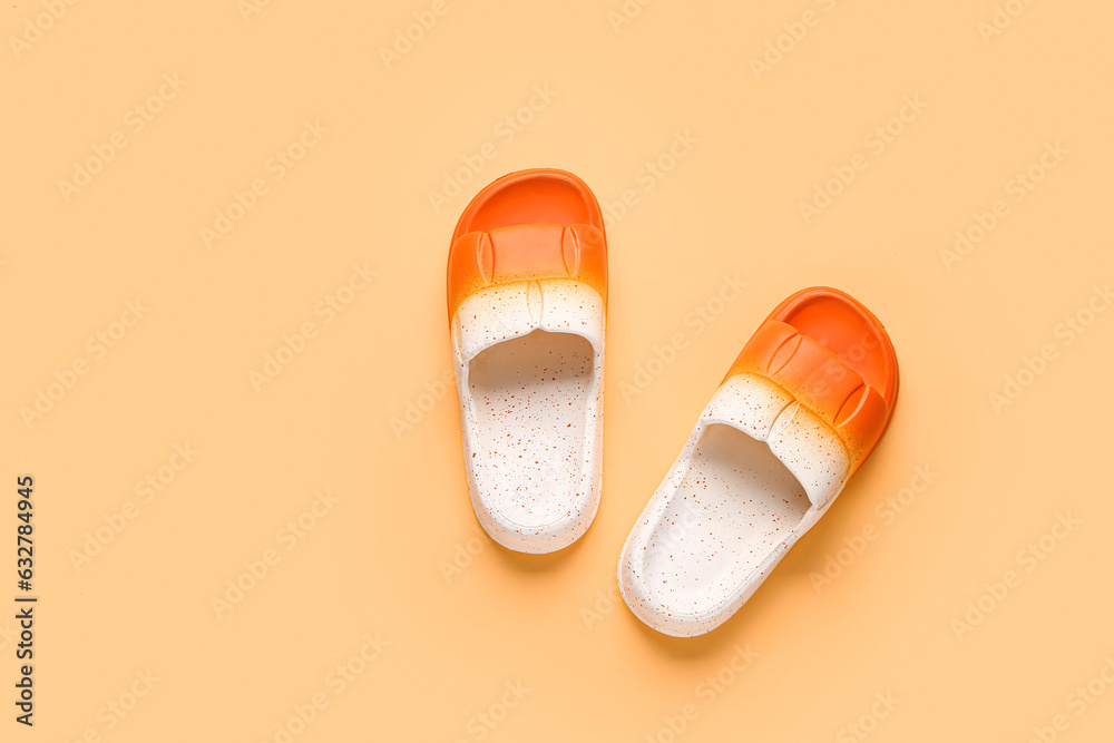 Female stylish flip flops on orange background