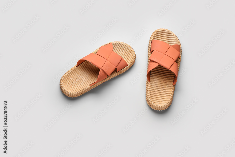 Female stylish flip flops on beige background