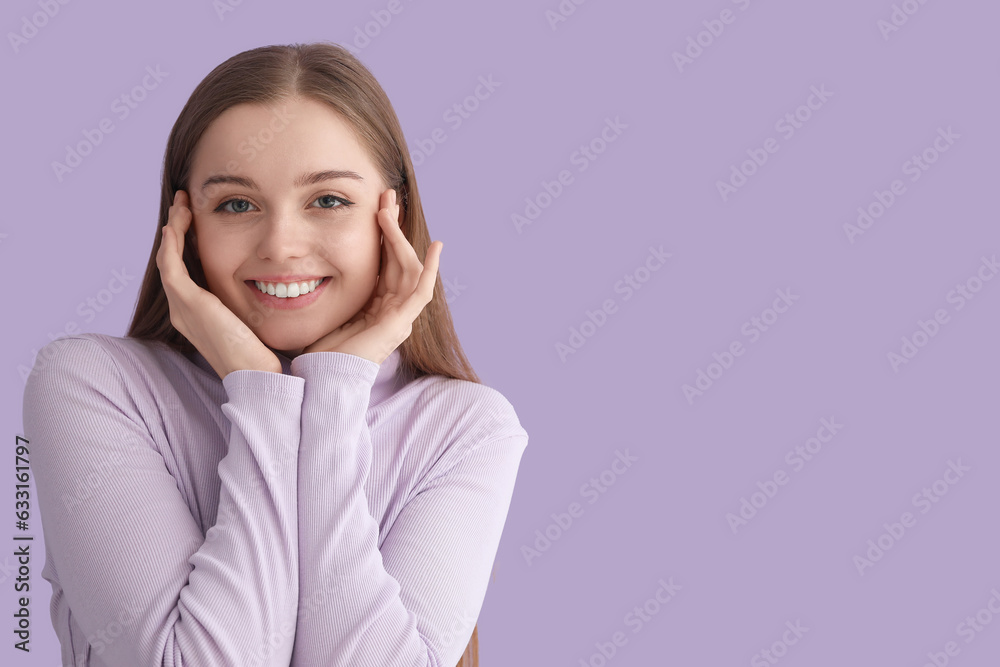 Young woman in sweater smiling on lilac background