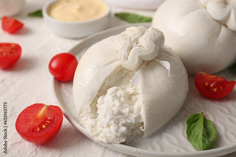 Plate with tasty Burrata cheese on white background