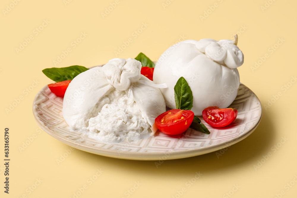 Plate with tasty Burrata cheese on yellow background