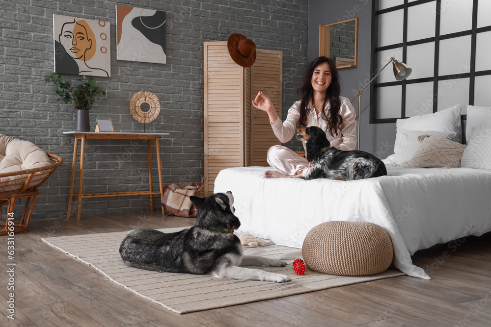 Young woman with cute dogs in bedroom