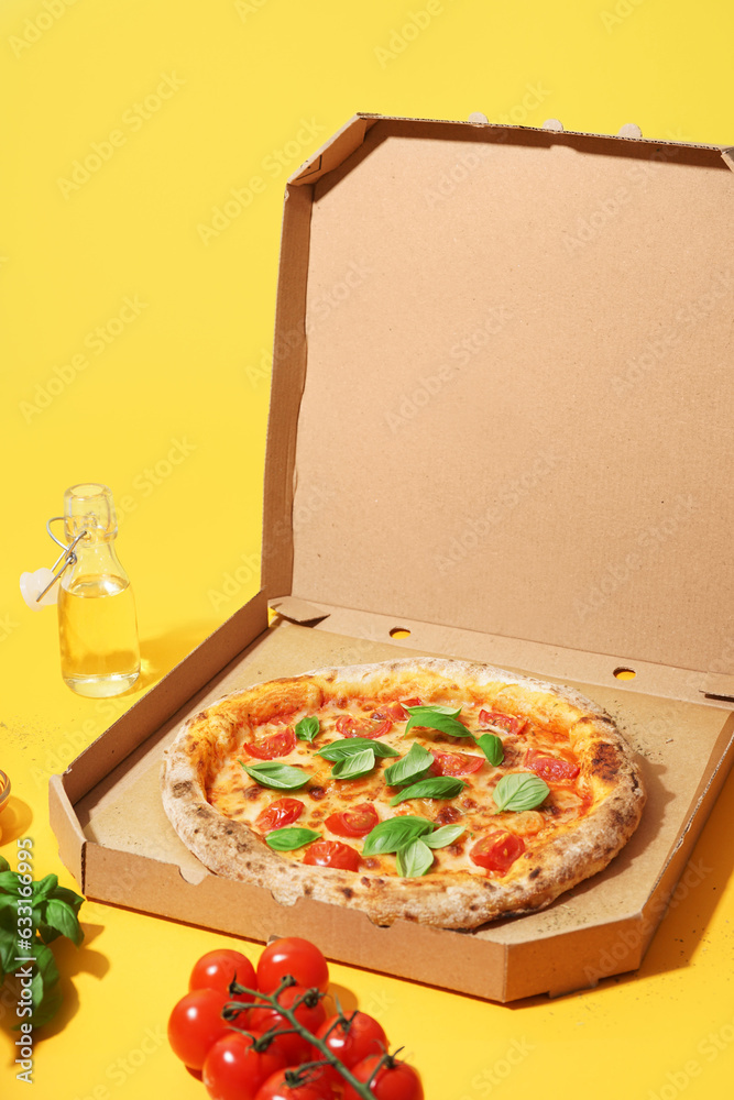 Carton box with tasty pizza Margarita on yellow background