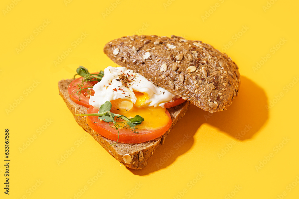 Tasty sandwich with egg on yellow background