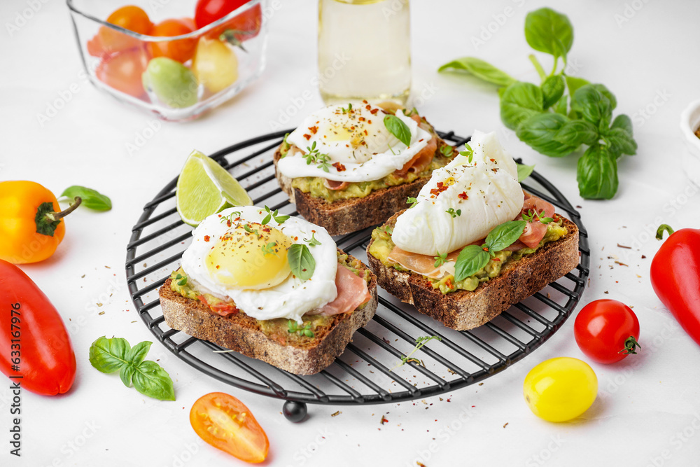 Grid of tasty sandwiches with egg on grey background