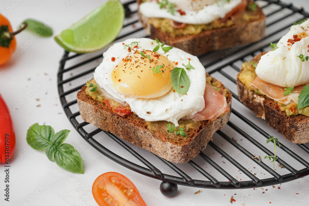 Grid of tasty sandwiches with egg on grey background