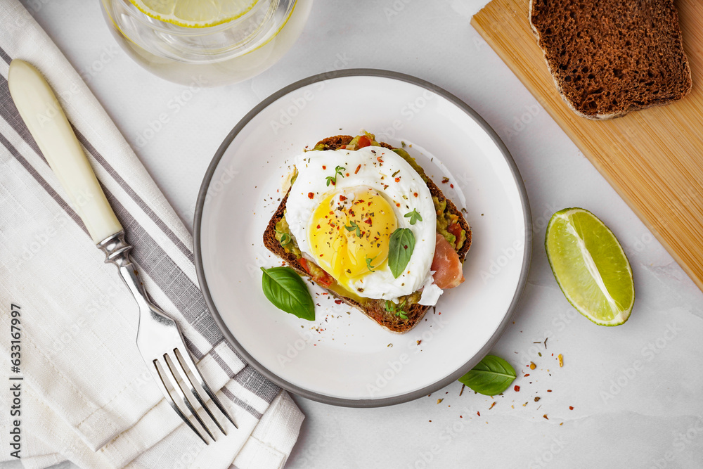 Plate of tasty sandwich with egg on grey background