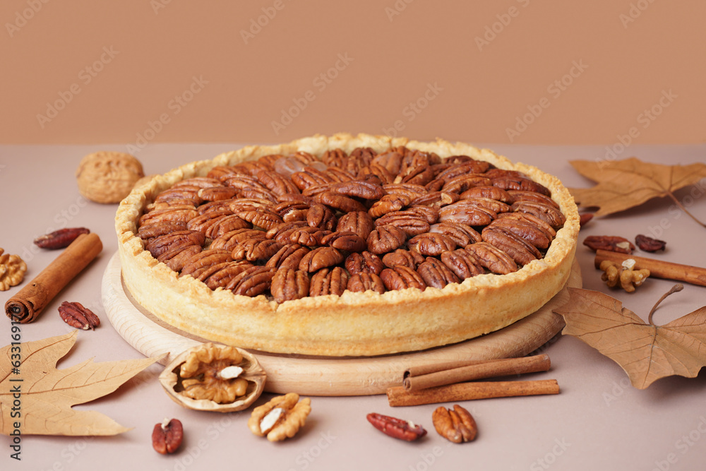 Wooden board with tasty pecan pie on beige background