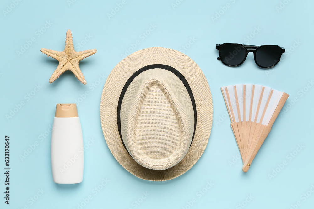 Composition with beach accessories and bottle of sunscreen cream on color background