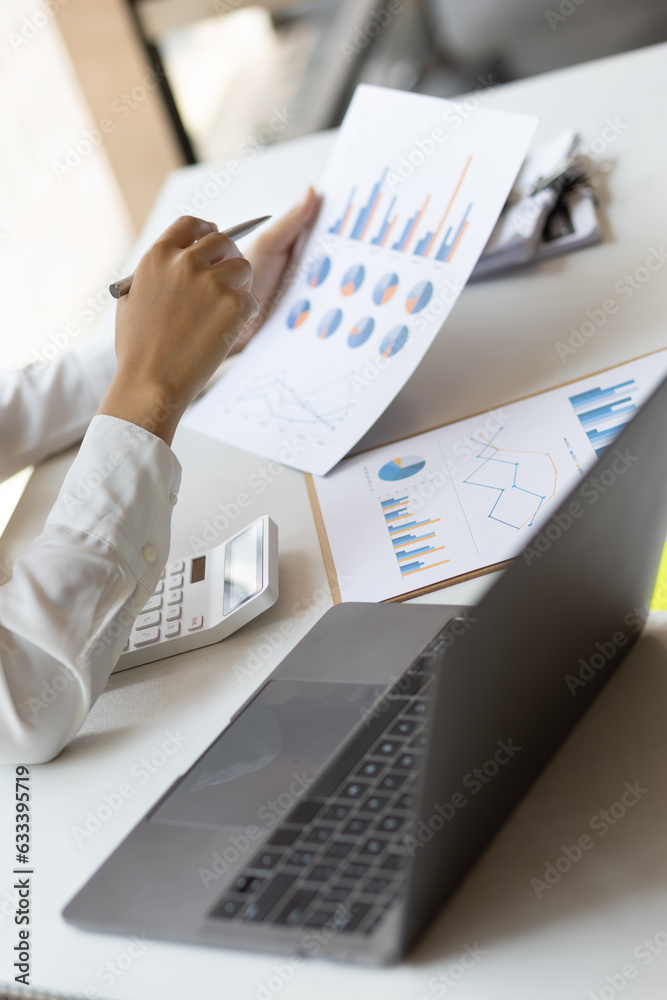 Business woman working on paperwork in the office, analysis of financial charts in business reports.