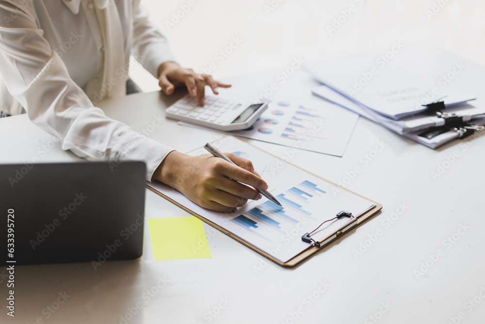 Business woman working on paperwork in the office, analysis of financial charts in business reports.