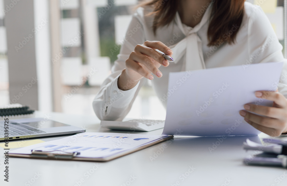 Business woman working on paperwork in the office, analysis of financial charts in business reports.