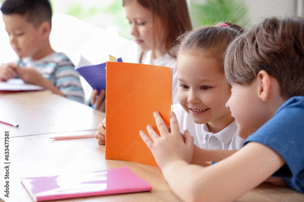 Little pupils having lesson in classroom