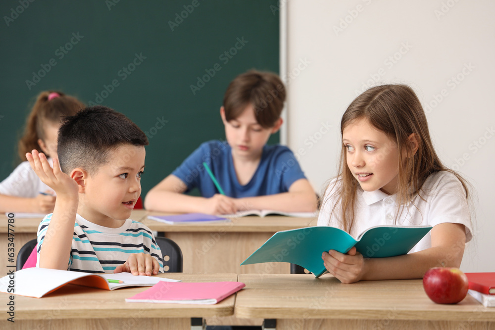 Little pupils having lesson in classroom