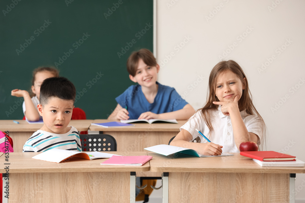 Little pupils having lesson in classroom