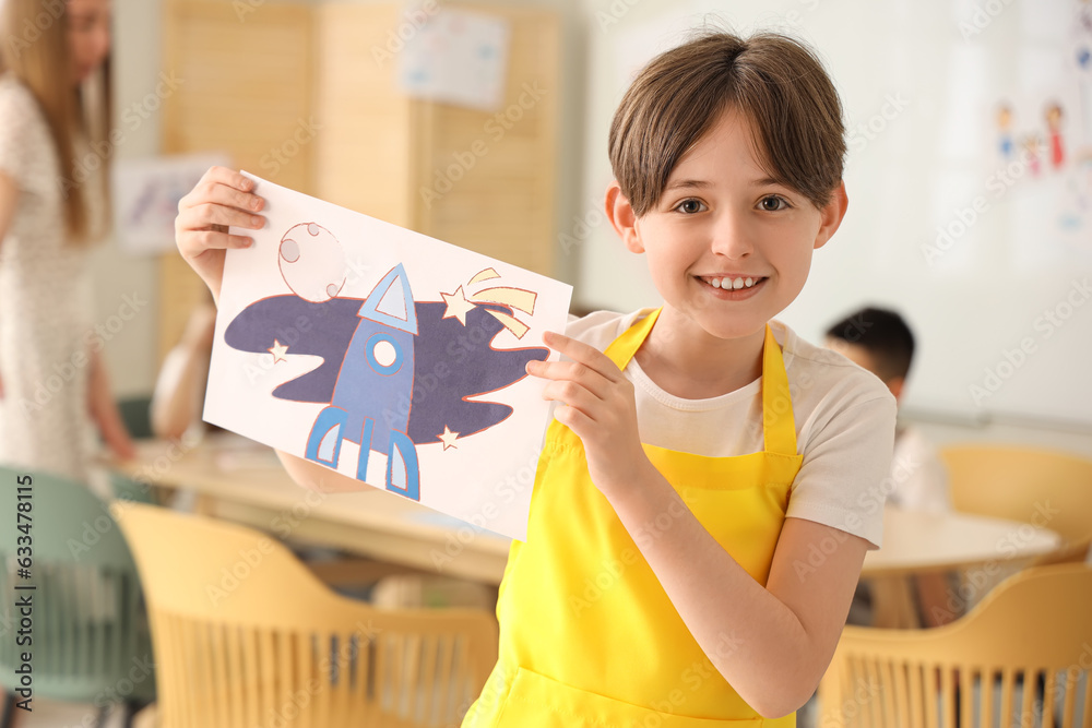 Little boy with drawing in art class