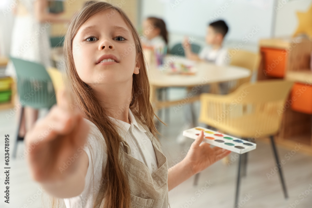 Little girl with paints in art class, closeup