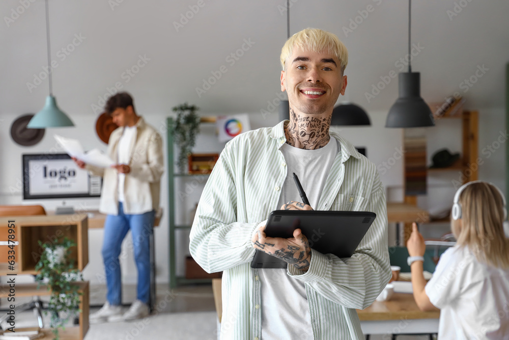 Male graphic designer working with tablet in office